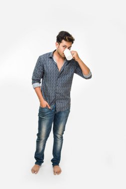 Bir fincan kahve, beyaz arka plan üzerinde izole ayakta olan genç yakışıklı bir Hintli adam portresi