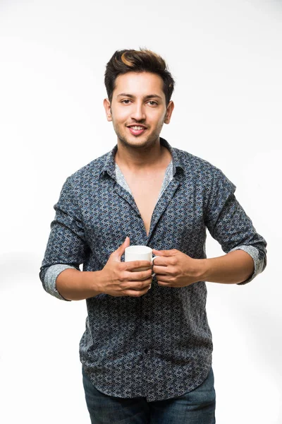 Ritratto di un giovane bell'uomo indiano che prende una tazza di caffè, isolato su sfondo bianco — Foto Stock