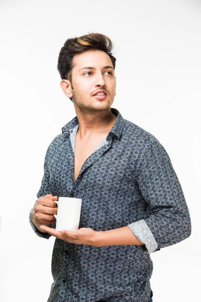 Porträtt av en ung stilig indiska man med en kopp kaffe, står isolerade över vit bakgrund — Stockfoto