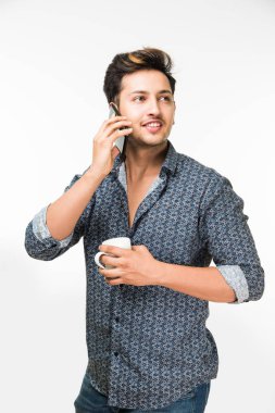 Bir fincan kahve, beyaz arka plan üzerinde izole ayakta olan genç yakışıklı bir Hintli adam portresi