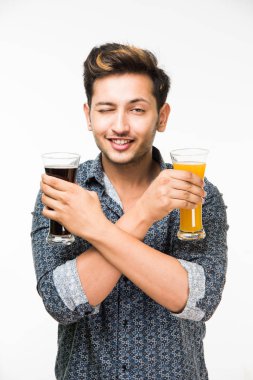 2 gözlük: genç yakışıklı Hintli kahvaltı için ya da serinlemek için iki bardak taze portakal suyu ve karanlık gazlı içecek tutarak rahat gömlekli. 