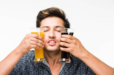 2 gözlük: genç yakışıklı Hintli kahvaltı için ya da serinlemek için iki bardak taze portakal suyu ve karanlık gazlı içecek tutarak rahat gömlekli. 