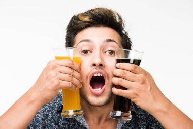 2 gözlük: genç yakışıklı Hintli kahvaltı için ya da serinlemek için iki bardak taze portakal suyu ve karanlık gazlı içecek tutarak rahat gömlekli. 