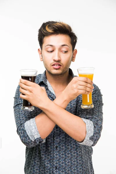 2 gözlük: genç yakışıklı Hintli kahvaltı için ya da serinlemek için iki bardak taze portakal suyu ve karanlık gazlı içecek tutarak rahat gömlekli. 