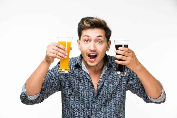 2 gözlük: genç yakışıklı Hintli kahvaltı için ya da serinlemek için iki bardak taze portakal suyu ve karanlık gazlı içecek tutarak rahat gömlekli. 