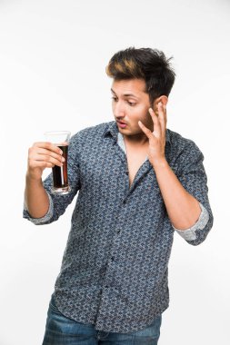 2 gözlük: genç yakışıklı Hintli kahvaltı için ya da serinlemek için iki bardak taze portakal suyu ve karanlık gazlı içecek tutarak rahat gömlekli. 