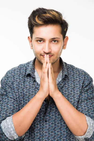 İyi görünümlü Kızılderili ya da Asyalı genç adam arka plan karşı katlanmış ellerle rahat soyunma portresi