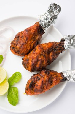 Tavuk Tangri kabab veya kebap - sonra ızgara ve salata ile servis kırmızı sos ile marine edilmiş üç tavuk bacak parçaları. Bu yeşil Hint turşusu ile servis edilebilir