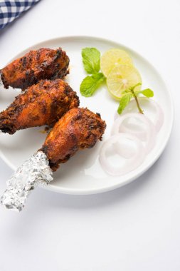 Tavuk Tangri kabab veya kebap - sonra ızgara ve salata ile servis kırmızı sos ile marine edilmiş üç tavuk bacak parçaları. Bu yeşil Hint turşusu ile servis edilebilir