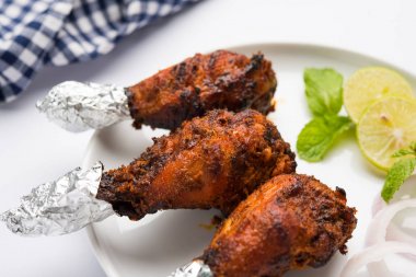 Tavuk Tangri kabab veya kebap - sonra ızgara ve salata ile servis kırmızı sos ile marine edilmiş üç tavuk bacak parçaları. Bu yeşil Hint turşusu ile servis edilebilir
