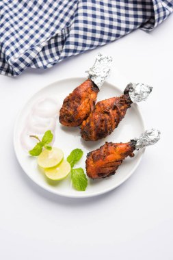 Tavuk Tangri kabab veya kebap - sonra ızgara ve salata ile servis kırmızı sos ile marine edilmiş üç tavuk bacak parçaları. Bu yeşil Hint turşusu ile servis edilebilir