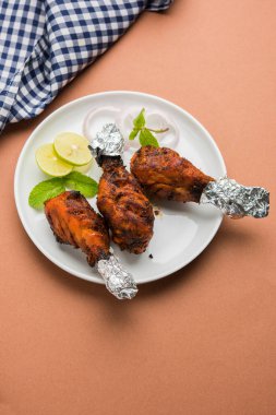 Tavuk Tangri kabab veya kebap - sonra ızgara ve salata ile servis kırmızı sos ile marine edilmiş üç tavuk bacak parçaları. Bu yeşil Hint turşusu ile servis edilebilir