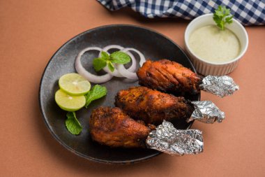 Tavuk Tangri kabab veya kebap - sonra ızgara ve salata ile servis kırmızı sos ile marine edilmiş üç tavuk bacak parçaları. Bu yeşil Hint turşusu ile servis edilebilir