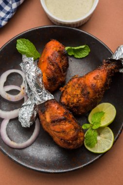 Tavuk Tangri kabab veya kebap - sonra ızgara ve salata ile servis kırmızı sos ile marine edilmiş üç tavuk bacak parçaları. Bu yeşil Hint turşusu ile servis edilebilir