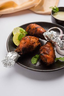 Tavuk Tangri kabab veya kebap - sonra ızgara ve salata ile servis kırmızı sos ile marine edilmiş üç tavuk bacak parçaları. Bu yeşil Hint turşusu ile servis edilebilir