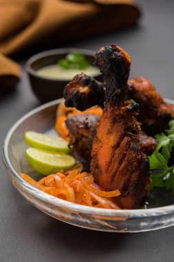 Tavuk Tangri kabab veya kebap - sonra ızgara ve salata ile servis kırmızı sos ile marine edilmiş üç tavuk bacak parçaları. Bu yeşil Hint turşusu ile servis edilebilir