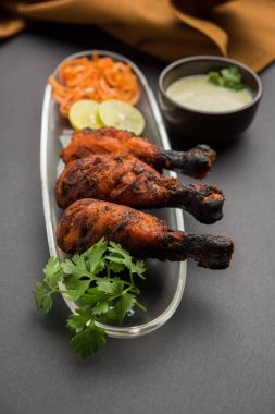 Tavuk Tangri kabab veya kebap - sonra ızgara ve salata ile servis kırmızı sos ile marine edilmiş üç tavuk bacak parçaları. Bu yeşil Hint turşusu ile servis edilebilir