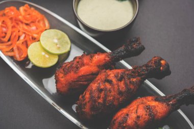 Tavuk Tangri kabab veya kebap - sonra ızgara ve salata ile servis kırmızı sos ile marine edilmiş üç tavuk bacak parçaları. Bu yeşil Hint turşusu ile servis edilebilir