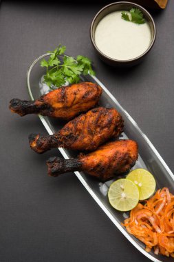 Tavuk Tangri kabab veya kebap - sonra ızgara ve salata ile servis kırmızı sos ile marine edilmiş üç tavuk bacak parçaları. Bu yeşil Hint turşusu ile servis edilebilir