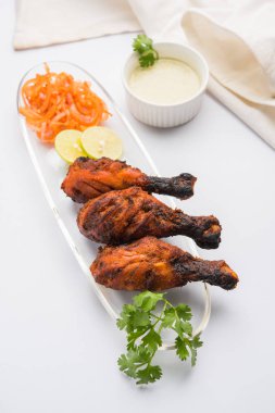 Tavuk Tangri kabab veya kebap - sonra ızgara ve salata ile servis kırmızı sos ile marine edilmiş üç tavuk bacak parçaları. Bu yeşil Hint turşusu ile servis edilebilir