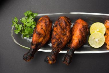 Tavuk Tangri kabab veya kebap - sonra ızgara ve salata ile servis kırmızı sos ile marine edilmiş üç tavuk bacak parçaları. Bu yeşil Hint turşusu ile servis edilebilir