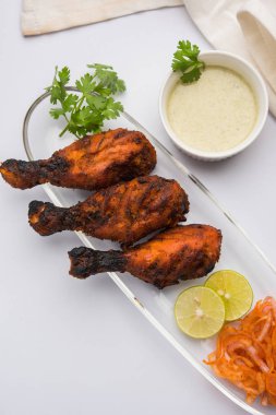 Tavuk Tangri kabab veya kebap - sonra ızgara ve salata ile servis kırmızı sos ile marine edilmiş üç tavuk bacak parçaları. Bu yeşil Hint turşusu ile servis edilebilir