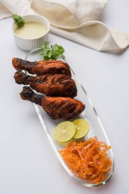 Tavuk Tangri kabab veya kebap - sonra ızgara ve salata ile servis kırmızı sos ile marine edilmiş üç tavuk bacak parçaları. Bu yeşil Hint turşusu ile servis edilebilir