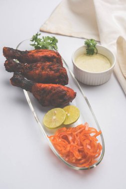 Tavuk Tangri kabab veya kebap - sonra ızgara ve salata ile servis kırmızı sos ile marine edilmiş üç tavuk bacak parçaları. Bu yeşil Hint turşusu ile servis edilebilir