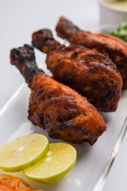 Tavuk Tangri kabab veya kebap - sonra ızgara ve salata ile servis kırmızı sos ile marine edilmiş üç tavuk bacak parçaları. Bu yeşil Hint turşusu ile servis edilebilir