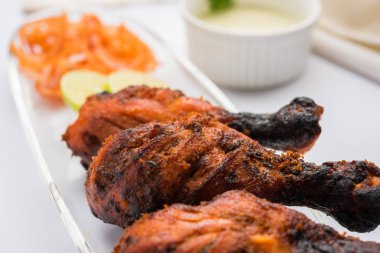 Tavuk Tangri kabab veya kebap - sonra ızgara ve salata ile servis kırmızı sos ile marine edilmiş üç tavuk bacak parçaları. Bu yeşil Hint turşusu ile servis edilebilir