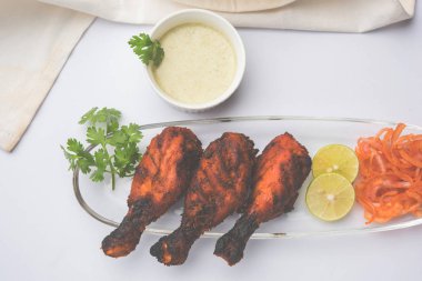 Tavuk Tangri kabab veya kebap - sonra ızgara ve salata ile servis kırmızı sos ile marine edilmiş üç tavuk bacak parçaları. Bu yeşil Hint turşusu ile servis edilebilir