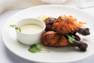 Tavuk Tangri kabab veya kebap - sonra ızgara ve salata ile servis kırmızı sos ile marine edilmiş üç tavuk bacak parçaları. Bu yeşil Hint turşusu ile servis edilebilir