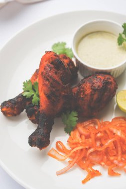 Tavuk Tangri kabab veya kebap - sonra ızgara ve salata ile servis kırmızı sos ile marine edilmiş üç tavuk bacak parçaları. Bu yeşil Hint turşusu ile servis edilebilir