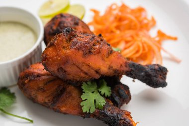 Tavuk Tangri kabab veya kebap - sonra ızgara ve salata ile servis kırmızı sos ile marine edilmiş üç tavuk bacak parçaları. Bu yeşil Hint turşusu ile servis edilebilir