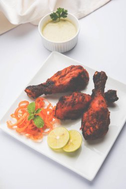 Tavuk Tangri kabab veya kebap - sonra ızgara ve salata ile servis kırmızı sos ile marine edilmiş üç tavuk bacak parçaları. Bu yeşil Hint turşusu ile servis edilebilir