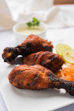 Tavuk Tangri kabab veya kebap - sonra ızgara ve salata ile servis kırmızı sos ile marine edilmiş üç tavuk bacak parçaları. Bu yeşil Hint turşusu ile servis edilebilir