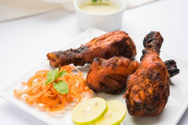 Tavuk Tangri kabab veya kebap - sonra ızgara ve salata ile servis kırmızı sos ile marine edilmiş üç tavuk bacak parçaları. Bu yeşil Hint turşusu ile servis edilebilir