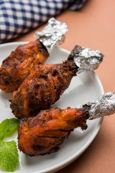 Tavuk Tangri kabab veya kebap - sonra ızgara ve salata ile servis kırmızı sos ile marine edilmiş üç tavuk bacak parçaları. Bu yeşil Hint turşusu ile servis edilebilir