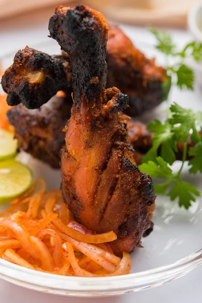 Tavuk Tangri kabab veya kebap - sonra ızgara ve salata ile servis kırmızı sos ile marine edilmiş üç tavuk bacak parçaları. Bu yeşil Hint turşusu ile servis edilebilir