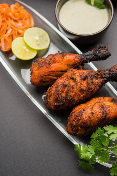 Tavuk Tangri kabab veya kebap - sonra ızgara ve salata ile servis kırmızı sos ile marine edilmiş üç tavuk bacak parçaları. Bu yeşil Hint turşusu ile servis edilebilir