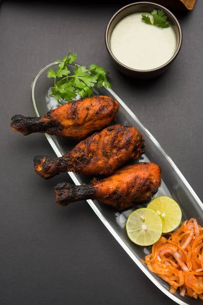 Tavuk Tangri kabab veya kebap - sonra ızgara ve salata ile servis kırmızı sos ile marine edilmiş üç tavuk bacak parçaları. Bu yeşil Hint turşusu ile servis edilebilir