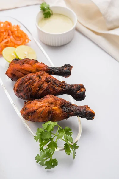 Tavuk Tangri kabab veya kebap - sonra ızgara ve salata ile servis kırmızı sos ile marine edilmiş üç tavuk bacak parçaları. Bu yeşil Hint turşusu ile servis edilebilir