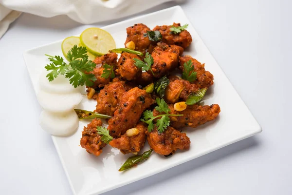 Chicken 65 - spicy deep fried Bar appetizer or quick snack from India in a frying pan over white background, selective focus — Stock Photo, Image