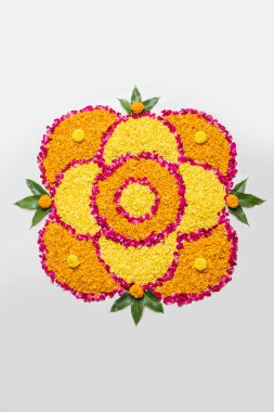 Rangoli Diwali için çiçek veya pongal diwali diya orta, seçici odak ile beyaz arka plan üzerinde kadife çiçeği veya zendu çiçekler ve kırmızı gül yaprakları kullanılarak yapılan