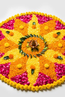 Rangoli Diwali için çiçek veya pongal diwali diya orta, seçici odak ile beyaz arka plan üzerinde kadife çiçeği veya zendu çiçekler ve kırmızı gül yaprakları kullanılarak yapılan