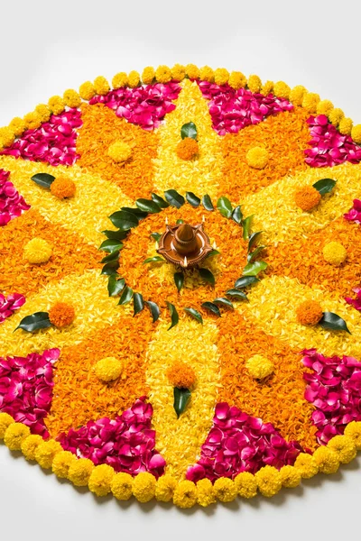 Rangoli Diwali için çiçek veya pongal diwali diya orta, seçici odak ile beyaz arka plan üzerinde kadife çiçeği veya zendu çiçekler ve kırmızı gül yaprakları kullanılarak yapılan