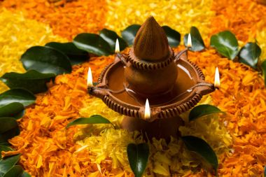 Rangoli Diwali için çiçek veya pongal diwali diya orta, seçici odak ile beyaz arka plan üzerinde kadife çiçeği veya zendu çiçekler ve kırmızı gül yaprakları kullanılarak yapılan