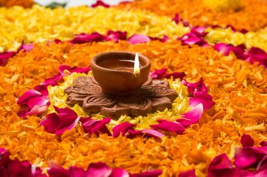 Rangoli Diwali için çiçek veya pongal diwali diya orta, seçici odak ile beyaz arka plan üzerinde kadife çiçeği veya zendu çiçekler ve kırmızı gül yaprakları kullanılarak yapılan