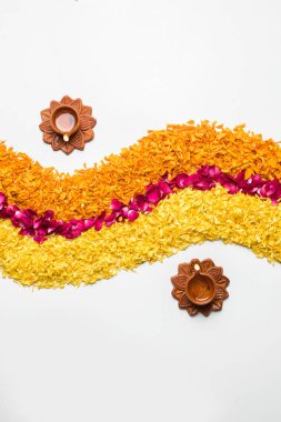 Rangoli Diwali için çiçek veya pongal diwali diya orta, seçici odak ile beyaz arka plan üzerinde kadife çiçeği veya zendu çiçekler ve kırmızı gül yaprakları kullanılarak yapılan