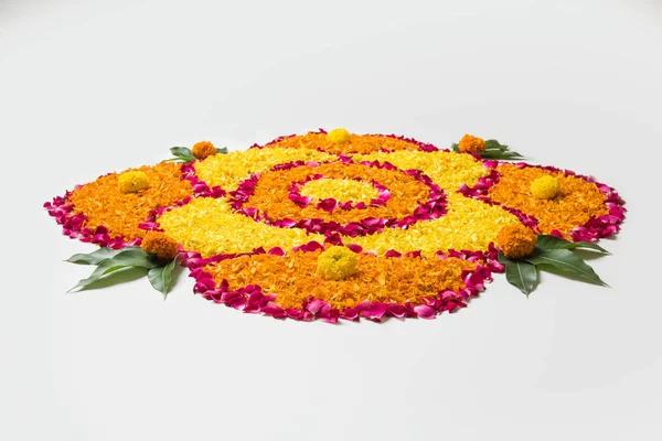 Rangoli Diwali için çiçek veya pongal diwali diya orta, seçici odak ile beyaz arka plan üzerinde kadife çiçeği veya zendu çiçekler ve kırmızı gül yaprakları kullanılarak yapılan